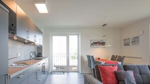 Eine moderne Wohnung mit Küche, Essbereich und Wohnzimmer.