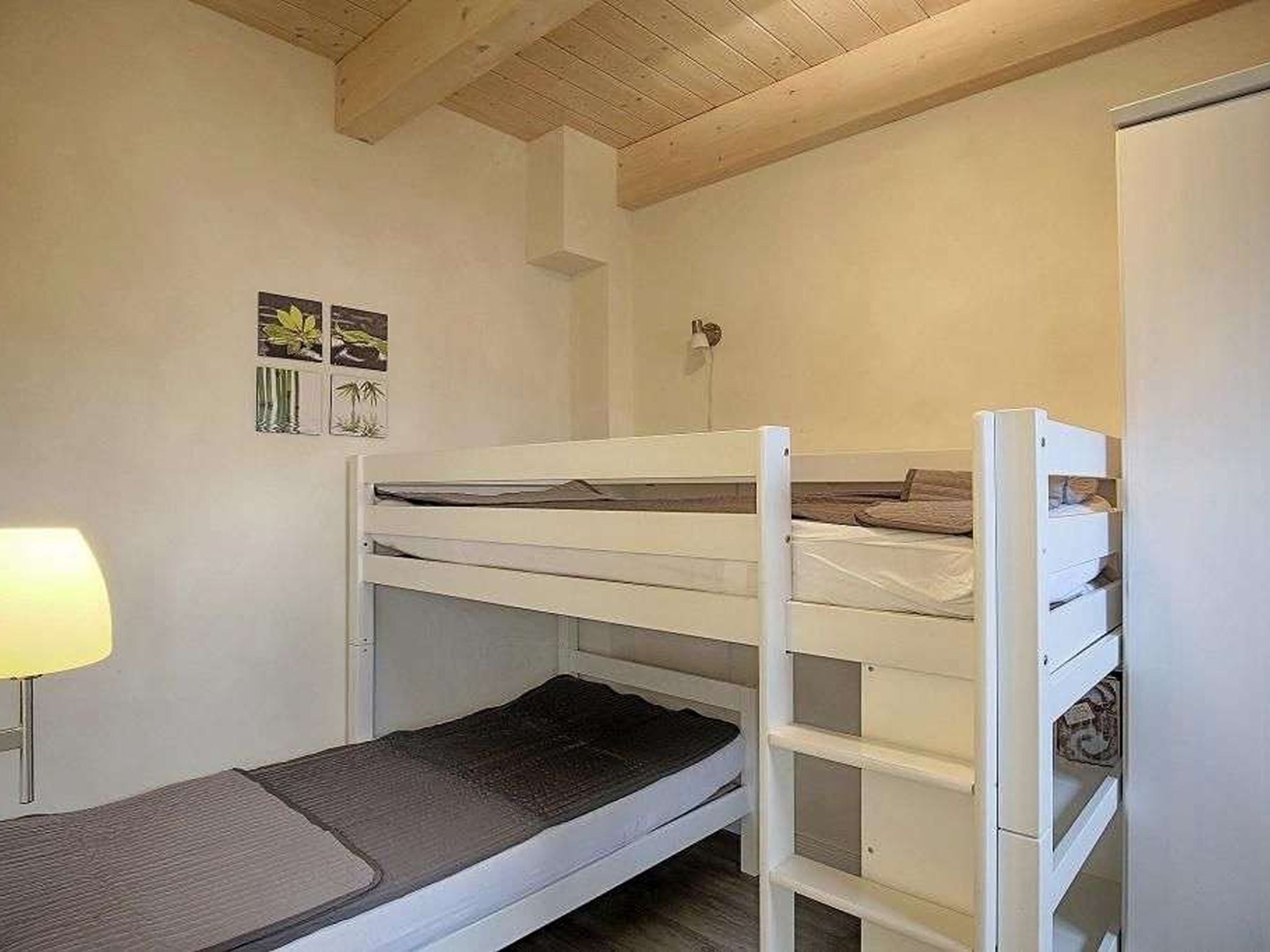 Habitació amb lliteres, escriptori i làmpada.