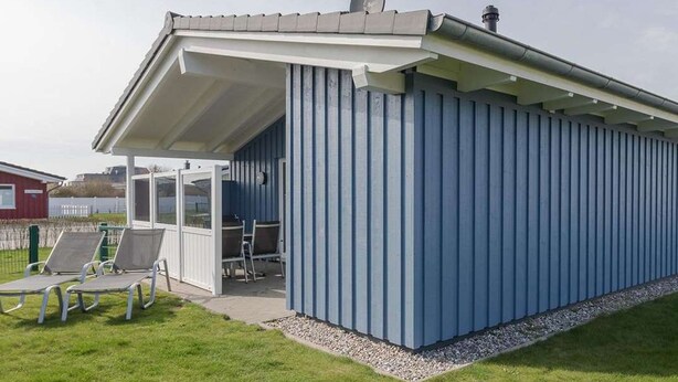 A blue building with a covered patio area, a satellite dish, and a ladder. - Vacation home Amrum by Interhome (Dagebüll)