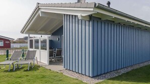 A blue building with a covered patio area, a satellite dish, and a ladder. - Syltrose by Interhome (Dagebüll)