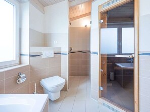 Bathroom features a toilet, bidet, and shower area with a glass door.