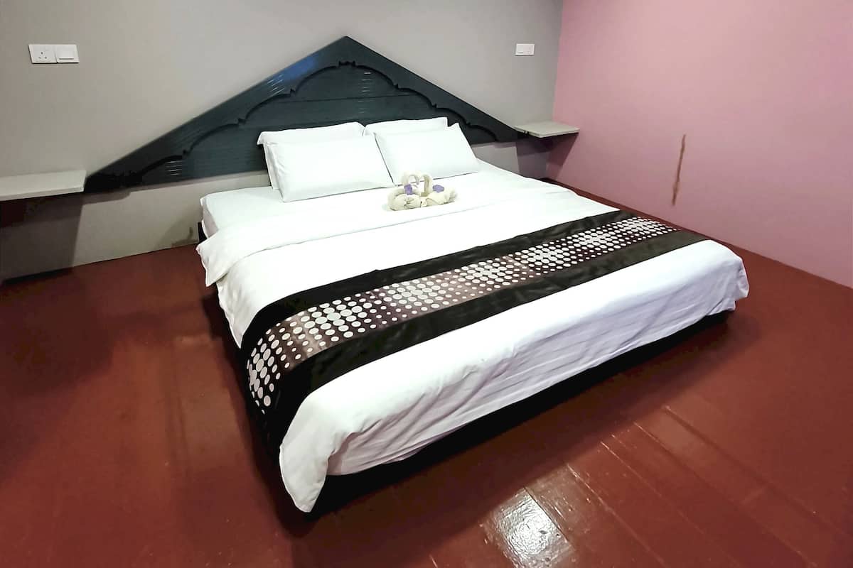Ein ordentlich bezogenes Bett mit weißer Bettwäsche und einer schwarz-weißen Tagesdecke.