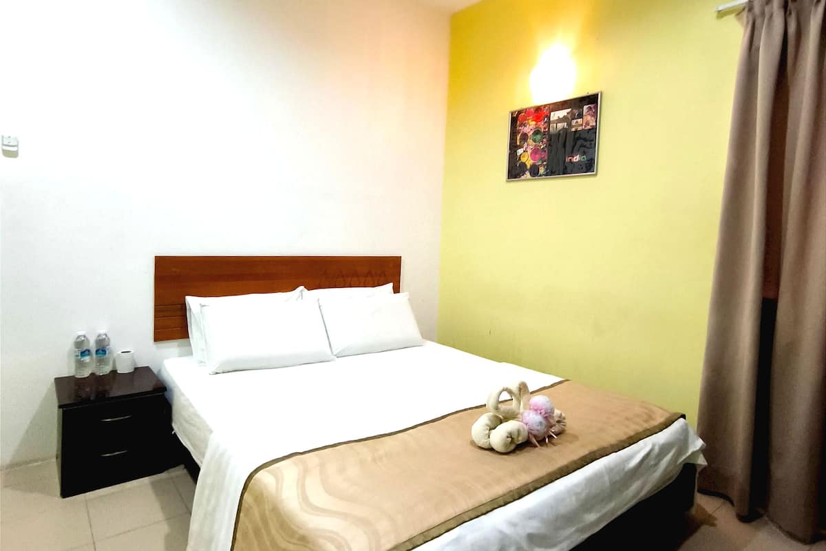 Ein Hotelzimmer mit einem Bett, einem Nachttisch, einem Wandbild und einem Vorhang.