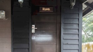 Een houten deur met een bordje met daarop de tekst 'Hanoi'.