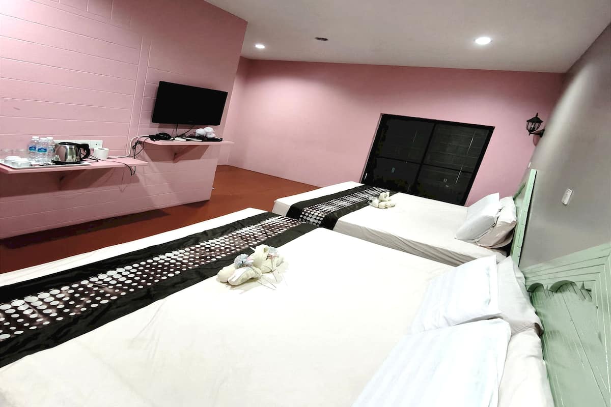 Ein Hotelzimmer mit rosafarbener Wand, einem an der Wand montierten Flachbildfernseher, einem Bett mit weißer Bettwäsche und einem schwarzen Zierläufer.
