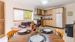A compact kitchen with wooden cabinets, a microwave, and a refrigerator. - Villa & Pool Apart in Mellieha Bay Apartments (Mellieha)
