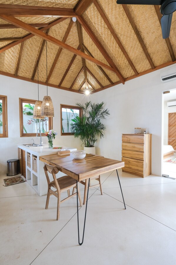 A spacious kitchen with a wooden table, a built-in island, and a ceiling fan.