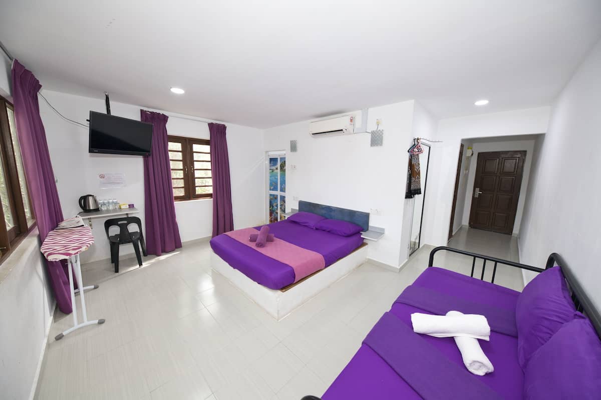 Ein Schlafzimmer mit Bett, Sofa, Schreibtisch und Fernseher.