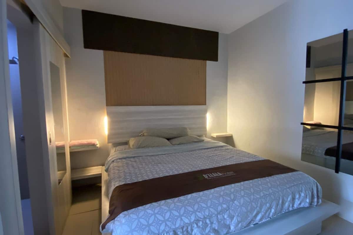 A modern bedroom with a bed, bedside tables, and a wardrobe.
