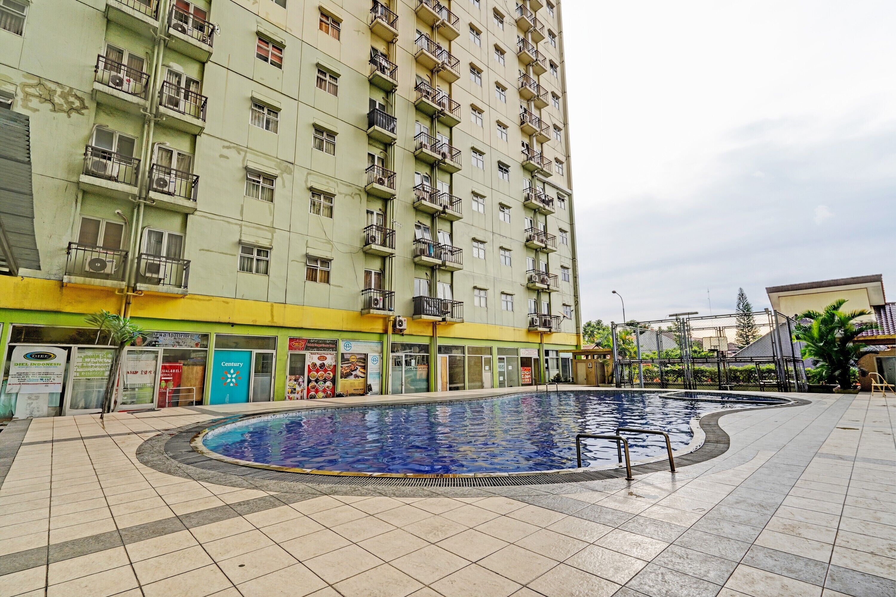 Un edifici residencial alt amb piscina al pati.