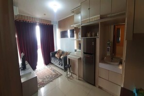 Family Studio | Living area | 32-inch flat-screen TV with cable channels - OYO 93439 The Suites Metro Apartment By Interindo (Bandung)