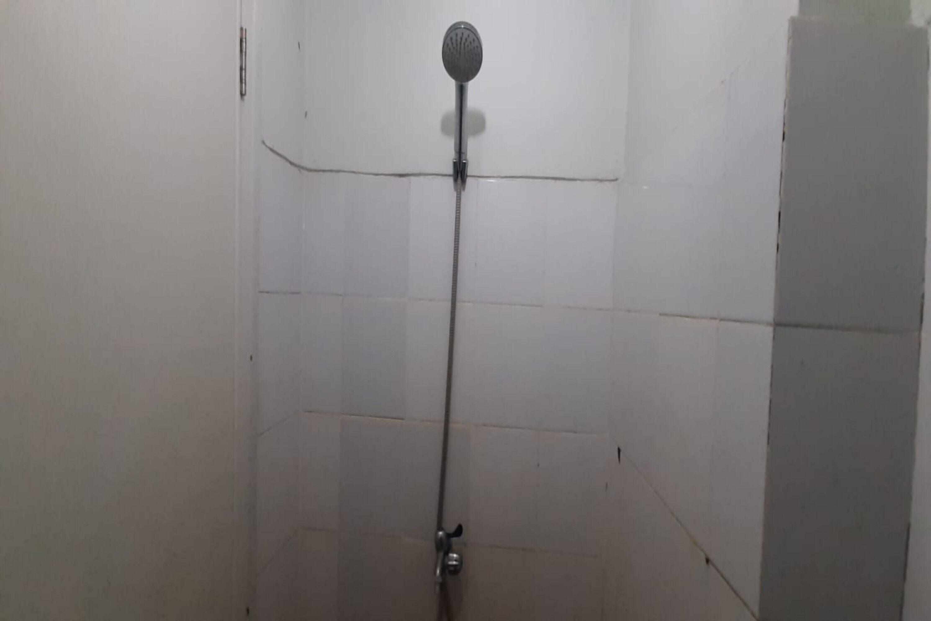 A shower with a handheld showerhead mounted on the wall.