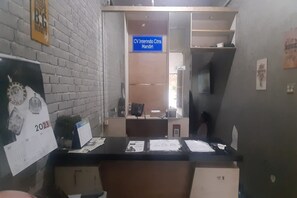 A reception desk with a calendar, papers, and a blue sign indicating 'CV Interindo Citra Mandini'.