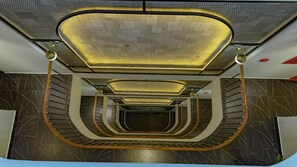 A spiral staircase with a modern design, featuring a patterned ceiling and walls with a marble-like texture. - The Elite Hotel (Xuan Huong - Da Lat)