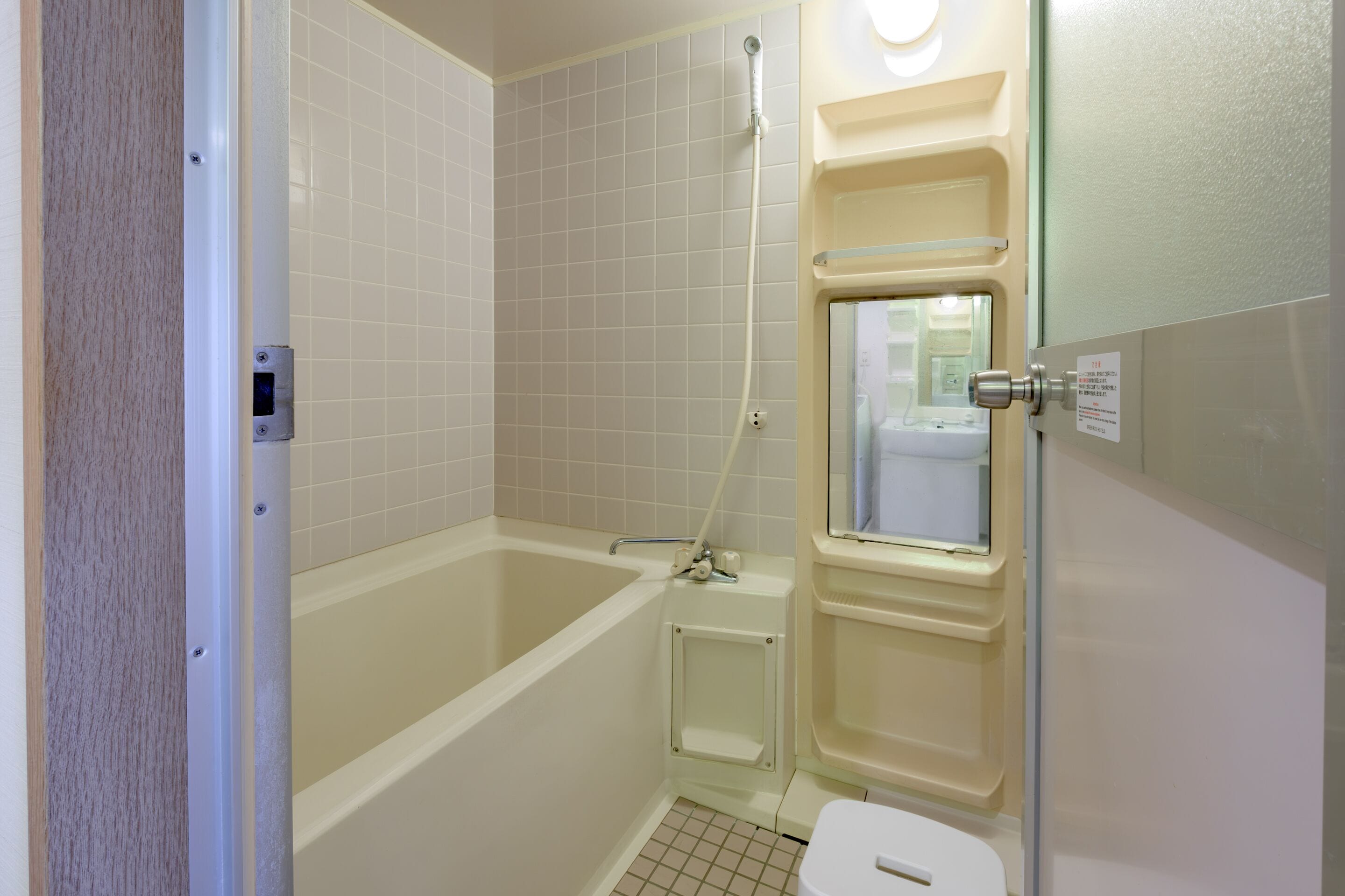 A small, clean bathroom with a bathtub, toilet, and a glass shower enclosure.