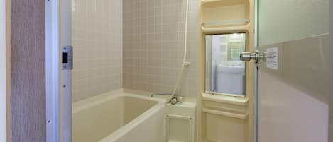 A small, clean bathroom with a bathtub, toilet, and a glass shower enclosure.