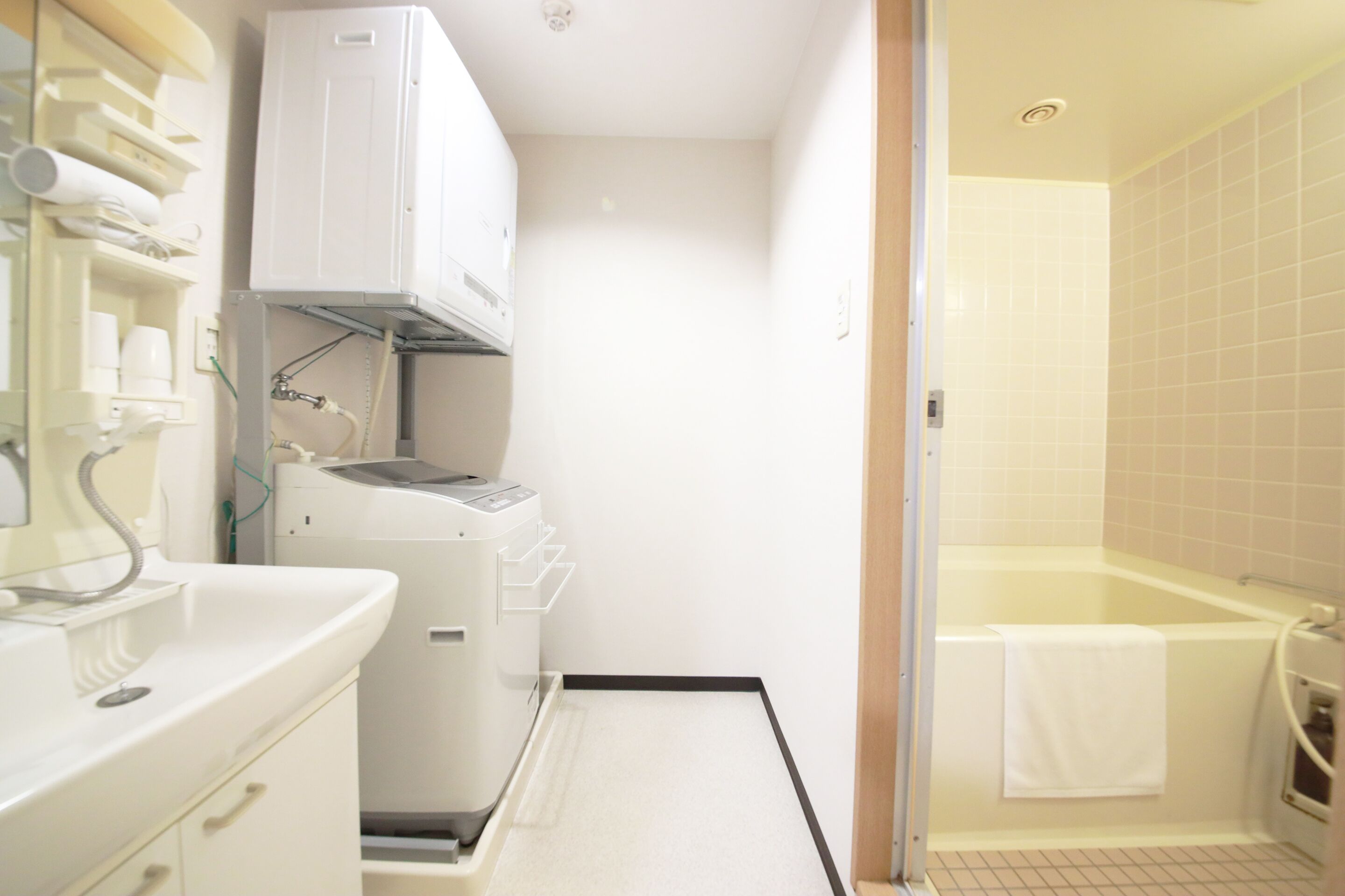 Un baño funcional con lavamanos, lavadora y bañera.