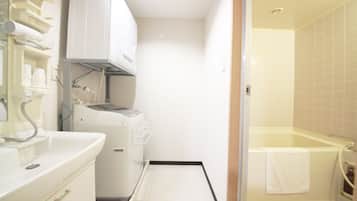 Un baño funcional con lavamanos, lavadora y bañera.