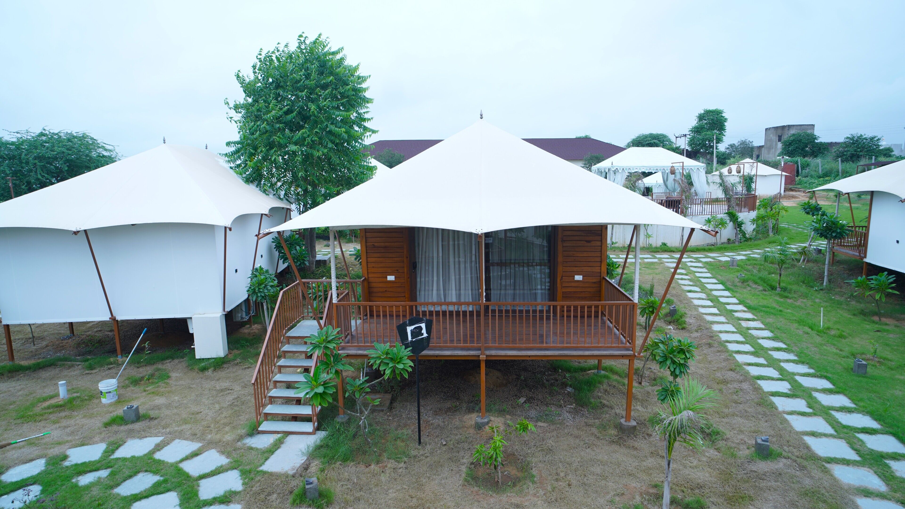 Une série de chalets blancs, à un seul étage, dotés de balcons en bois et reliés par un chemin pavé.