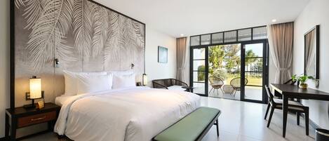 Una habitación de hotel moderna con una cama grande, un escritorio y un balcón con vistas.