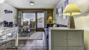 Een gezellige kamer met een eethoek, een bank, een lamp en een kast.