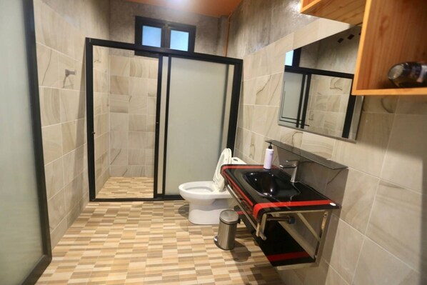 A bathroom with a shower, toilet, and sink.