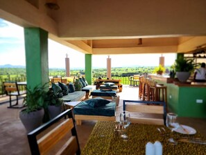 A terrace with seating, a table with cutlery, and a view of the landscape. - Heart&Soul Lodge (Lake Manyara National Park)