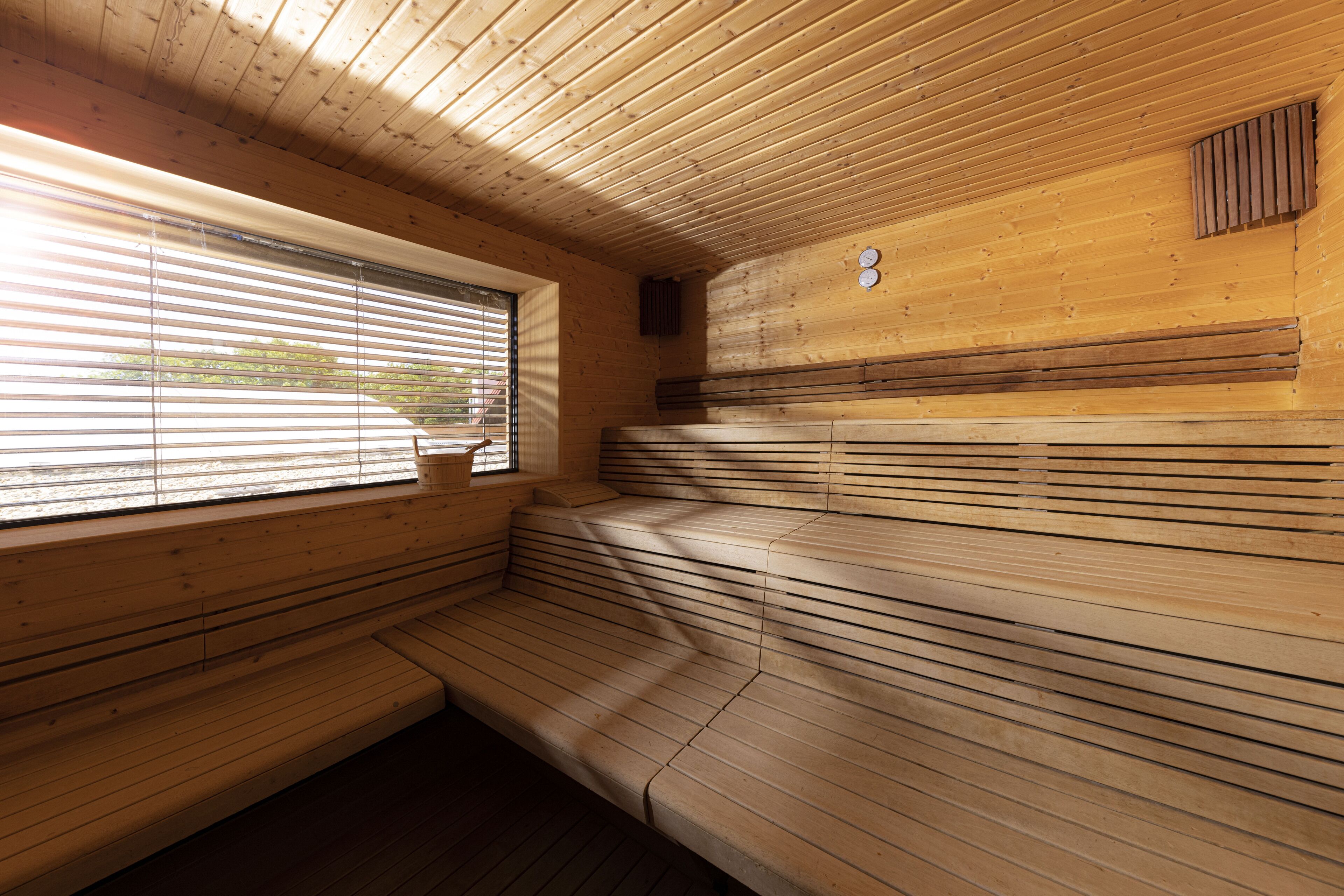 Un sauna avec des bancs en bois et une fenêtre.