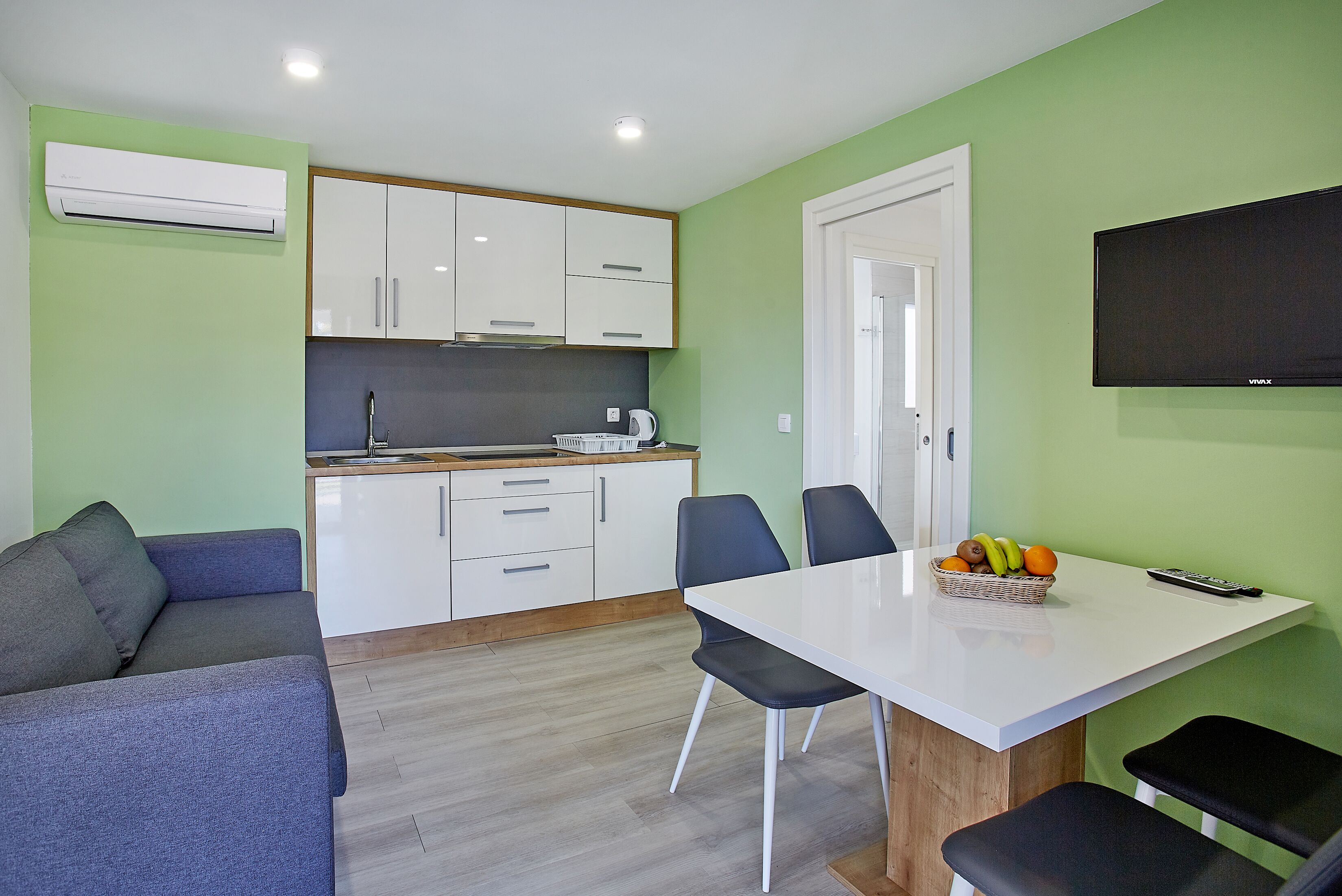 A compact living space with a kitchenette, a dining area, and a seating area.