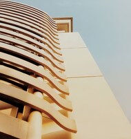 Un edificio moderno con fachada curva y entrada destacada.