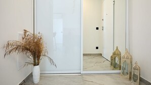 A hallway with a white door, a potted plant, and two ornate lanterns. - Hedera Estate, Hedera A45 (Dubrovnik)