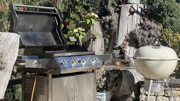 Una griglia da barbecue con un armadietto e un coperchio dedicato.