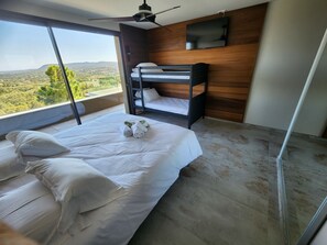 A bedroom with a large window, a bunk bed, and a flat-screen TV.