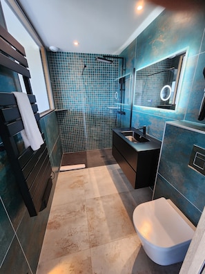 Une salle de bain moderne équipée d’une douche, d’un lavabo et de toilettes.