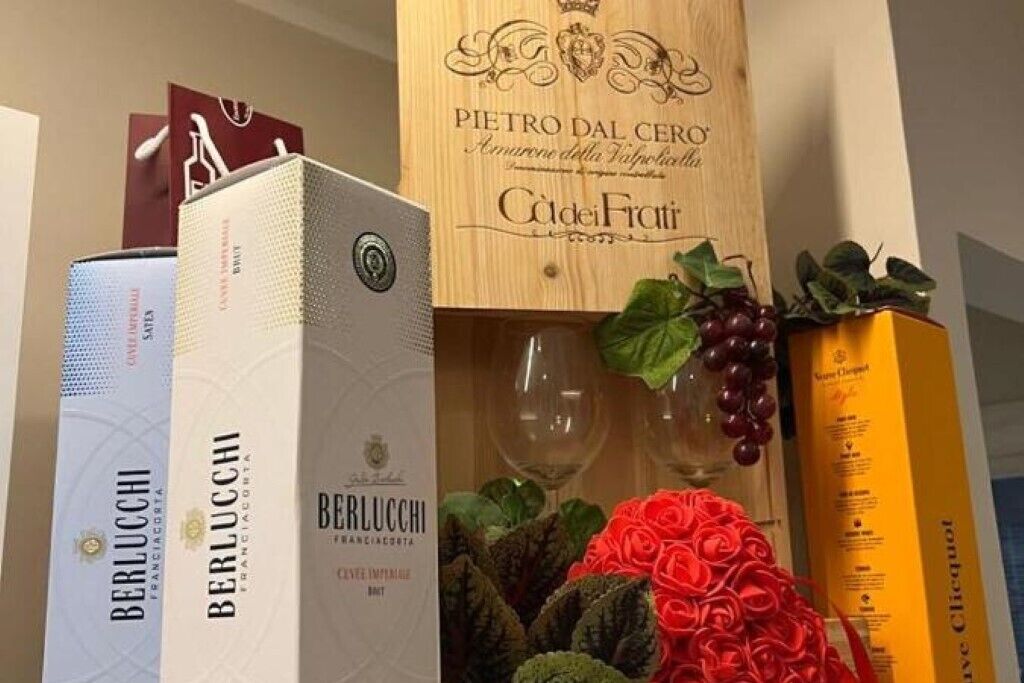 A display of wine boxes and a decorative arrangement with a glass and grapes.
