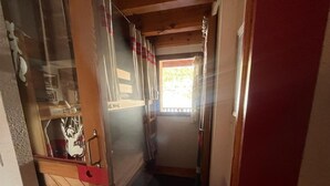 A narrow hallway with wooden walls and a door leading to a room. - 3-Room Duplex - Lake and Mountain View - Parking Included (Les Angles)