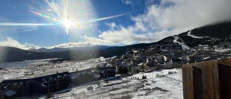 A snowy landscape with a town and mountains in the background.