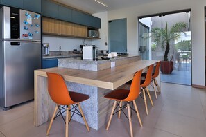 Una cocina moderna con una isla central, electrodomésticos de acero inoxidable y muebles de madera.