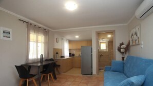 A compact living space with a dining area, kitchenette, and a sofa. - Olga Home Agios Ioannis Lefkada - Lefkada BnB (Lefkada)