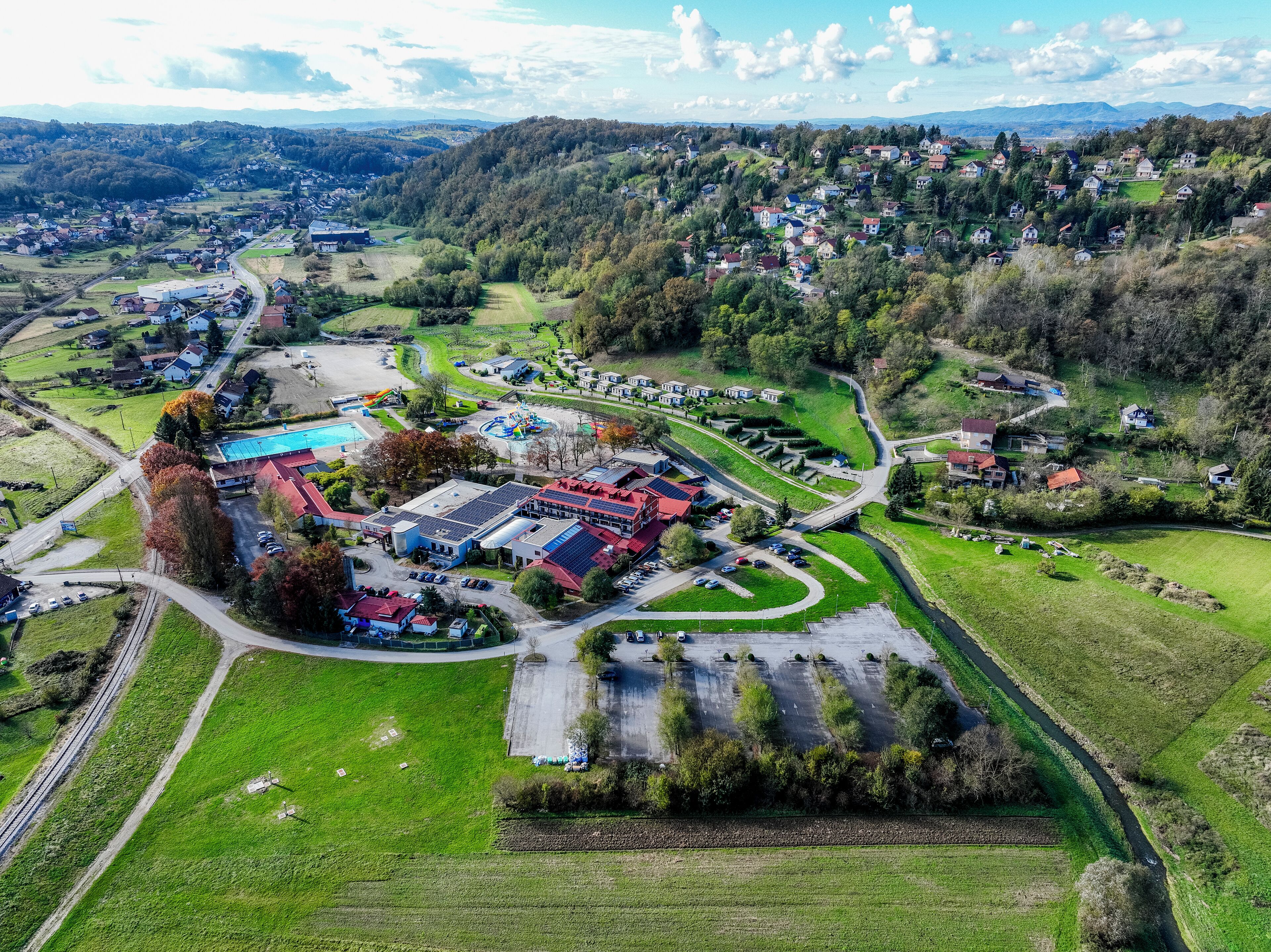 Vue aérienne d’une zone rurale comprenant un vaste complexe de bâtiments, des routes et des champs environnants.
