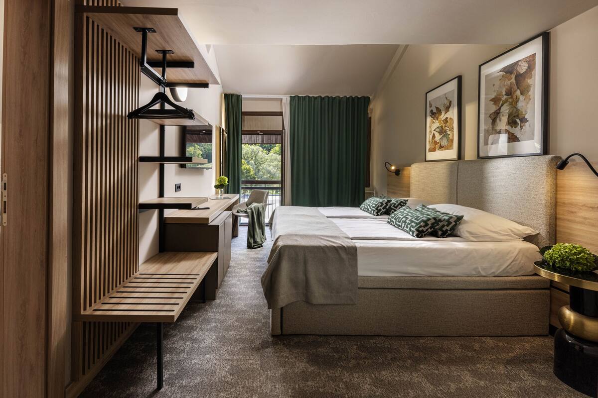 Een moderne hotelkamer met een bed, een bureau en een zithoek.