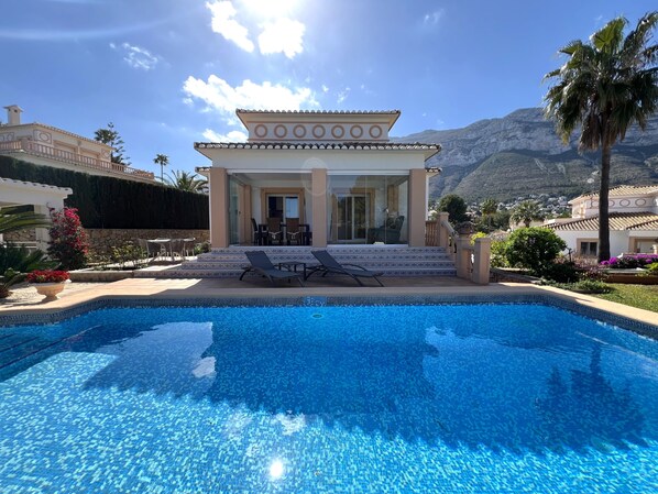 A poolside area with a clear view of a mountain range in the background.
