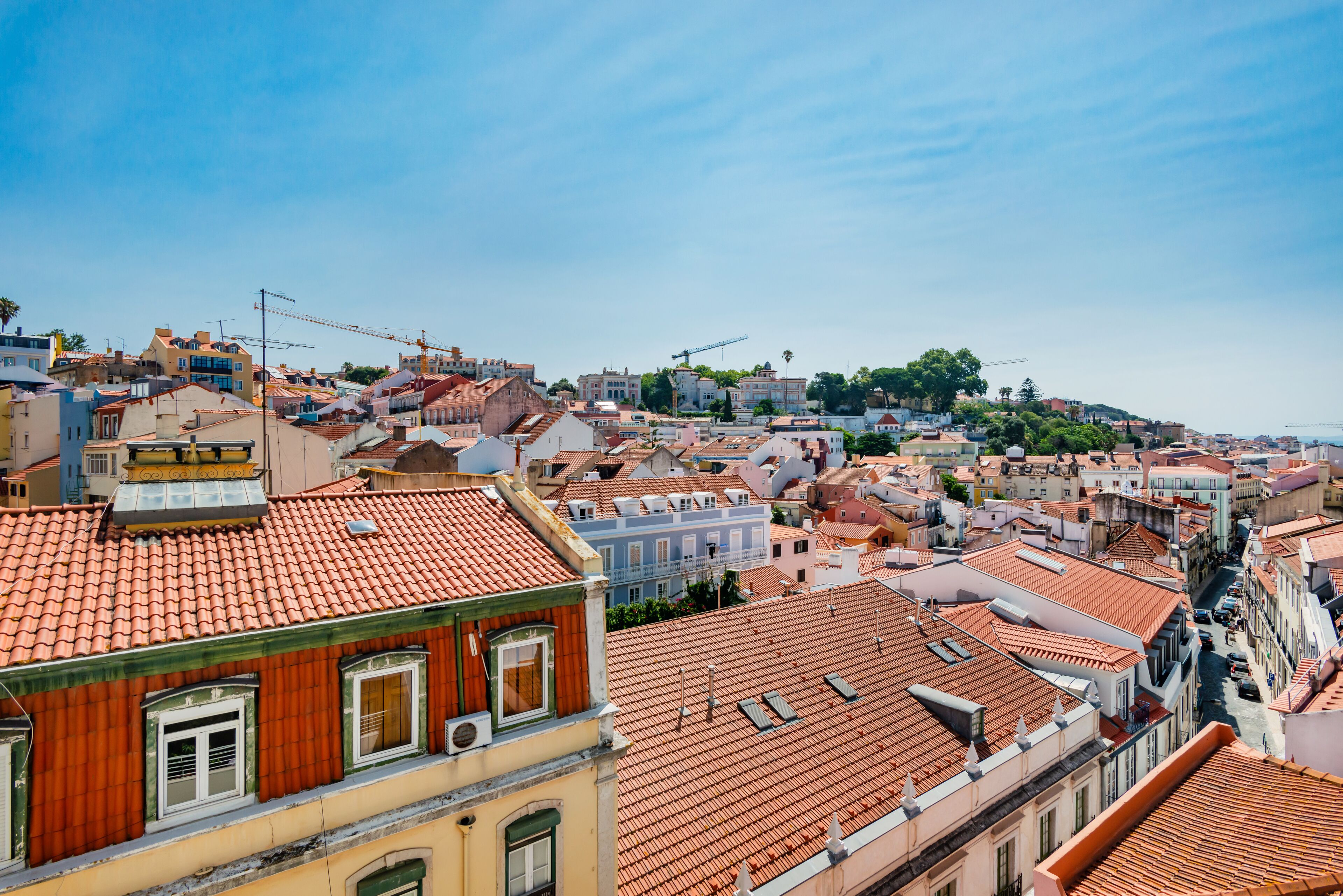 A cityscape with buildings featuring red-tiled roofs and a mix of architectural styles.
