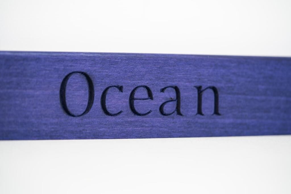 Painel de madeira com a palavra 'Ocean' gravada.
