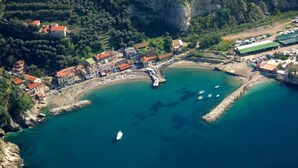 Vista aérea de un pueblo costero con edificios, una playa y un muelle.