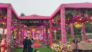 A decorated outdoor event space with floral arrangements and lighting. - Calista Resort (New Delhi)