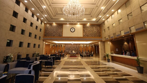 A spacious lobby with a chandelier, checkered floor, and a reception desk. - Calista Resort (New Delhi)