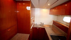 Una cucina compatta con mobili in legno, un lavello e una finestra.