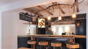 A modern kitchen with a central island, bar stools, and a hanging light fixture. - Luxury Larch Loft, perfect for groups/family of up to 6 people

 (Tesido BZ)