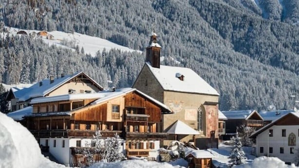 A traditional wooden lodge with multiple rooms, a central building with a bell tower, and a snowy mountainous backdrop. - Luxury Larch Loft, perfect for groups/family of up to 6 people

 (Tesido BZ)